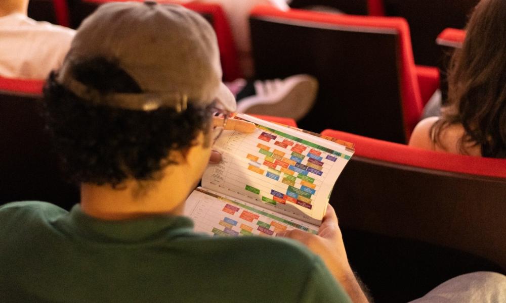 Persona revisando la programación del FICCI 64